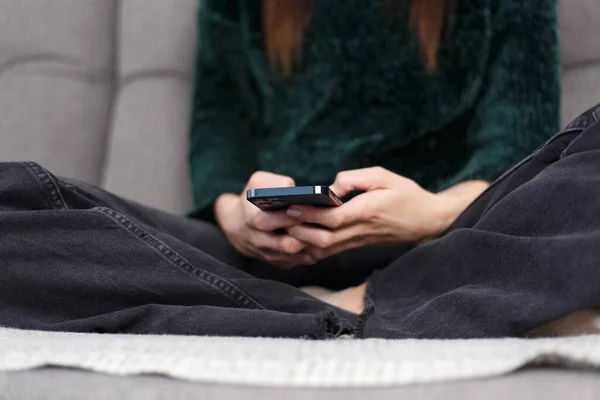 Νεαρή Γυναίκα Κάθεται Στον Καναπέ Και Πληκτρολογεί Sms Μήνυμα Στο — Φωτογραφία Αρχείου