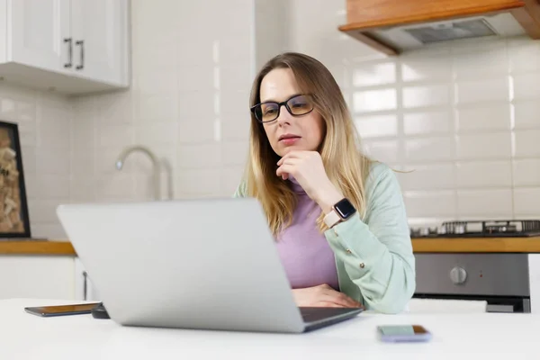 大人の白人女性は コンピュータ画面からテキストを読んでいます 集中し 家庭でラップトップ上で働くウクライナの女性 — ストック写真