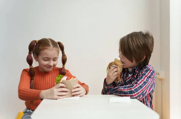 ギリシャのレストランでジャイロとスブラキを食べる2人の小さな子供 小学生の男の子と女の子がファーストフードカフェでランチを楽しんでいます — ストック写真