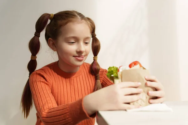 手にギリシャのSouvlakiサンドイッチと空腹の少女の肖像画 ヨーロッパのレストランでファーストフードを食べる大人の小学生 — ストック写真