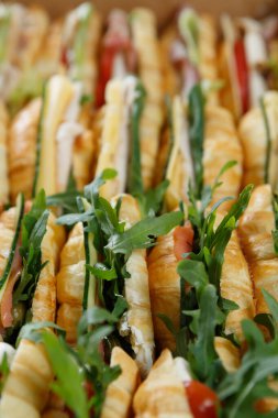 Büyük bir kutu taze kruvasan, roka, sebze ve kırmızı balık bir yerde yemek servisi için servis ediliyor.