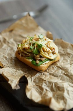 Lezzetli küçük bruschetta aperatifleri, haute restaurant 'da dekoratif parşömen kağıdında servis edilen mikro yeşilliklerle.