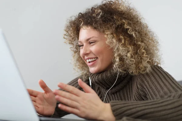 快乐的年轻女人卷曲的头发笑在一个视频通话 耳机里快乐的白人女性在网络电话会议上的发言 — 图库照片