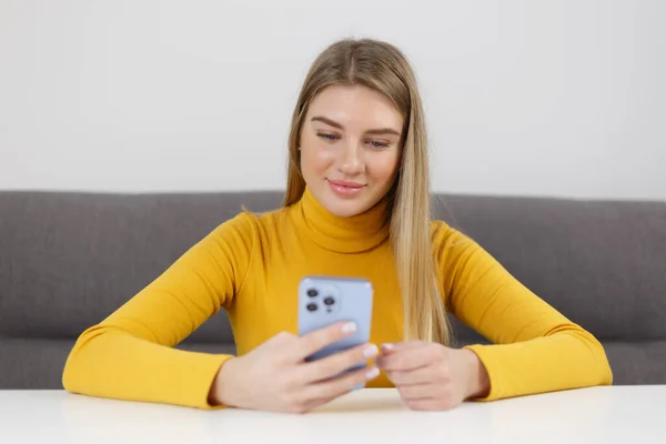快乐的金发女性在现代蓝色智能手机上浏览移动应用程序 快乐的乌克兰女孩用手机进行交流 — 图库照片
