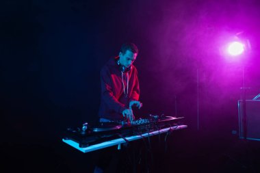 Profesyonel DJ hip hop partisinde plakları karıştırıyor. Gece kulübünde müzik çalan beyaz erkek.
