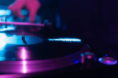 Turntable, karanlık gece kulübünde hip hop partisinde müzik eşliğinde analog vinil plak çalıyor.