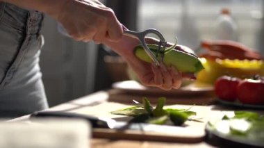 Ev hanımı salatalığı soyuyordu. Hem de yakından. Kadın evde öğle yemeği için sebze soyar.