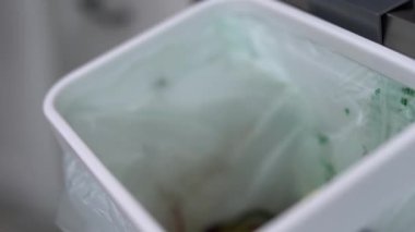 Gübre kutusuna yemek artıkları atan biri. Aşçı evdeki bir Bokashi konteynerinde organik atıkları geri dönüştürüyor.