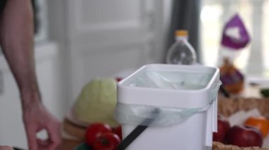 Erkek kişi organik gıda atıklarını gübre kutusuna atıyor ve fermantasyon için bokashi kepeği döküyor. Aşçı fermantasyon için gübre kutusuna bokashi mayası döküyor. Sürdürülebilir yaşam tarzı kavramı