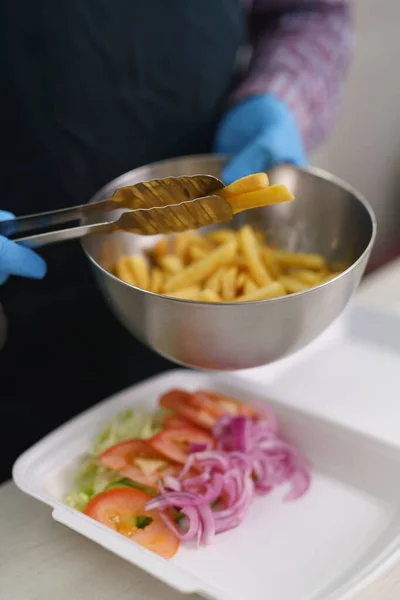감자튀김을 도시락에 넣었습니다 그리스의 패스트푸드 식당에서 요리사가 접시를 준비하는 — 스톡 사진