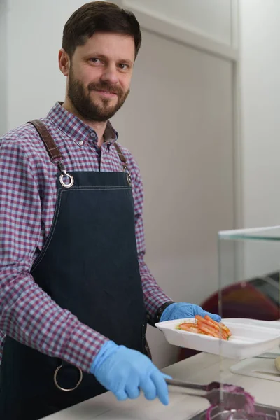 一个快乐的白人在快餐店做希腊卡拉马基菜的画像 — 图库照片