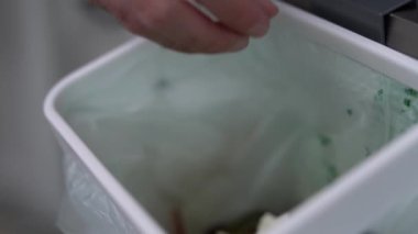 Aşçı, fermantasyon için organik gıda atıklarını gübre kutusuna atıyor. Bokashi mayalı bir konteynırda geri dönüşümlü gübre artıkları.