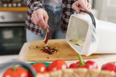 Kadın fermantasyon için gübre artıklarını bir bokashi kutusuna atıyor. Organik atıkları gübre kabında geri dönüştüren bir kadın.. 