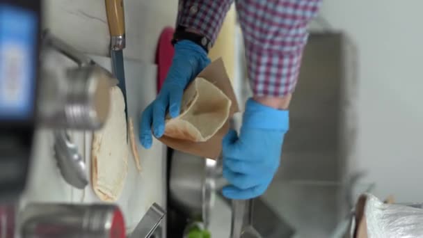 調理の垂直ビデオ調理準備ギリシャのピタSouvlakiサンドイッチでTzatzikiソースと新鮮な野菜 — ストック動画