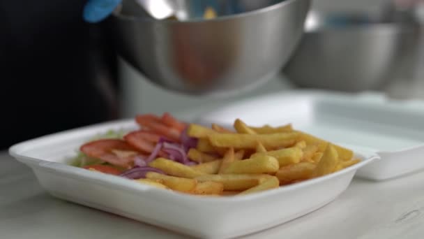 库克把薯条放在午餐盒里 厨房工人在希腊一家快餐店准备一道外卖菜 — 图库视频影像