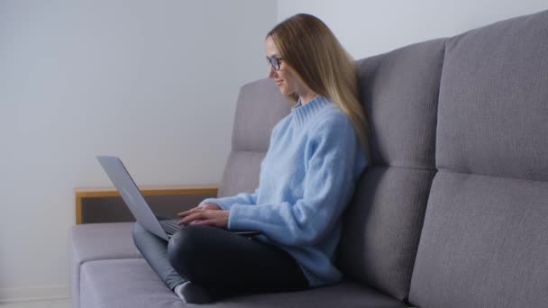 Jovem Mulher Digitando Texto Teclado Laptop Sofá Mulher Loira Bonita — Vídeo de Stock