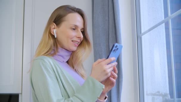 Vrolijke Oekraïense Vrouw Luisteren Naar Podcast Online Met Draadloze Hoofdtelefoon — Stockvideo