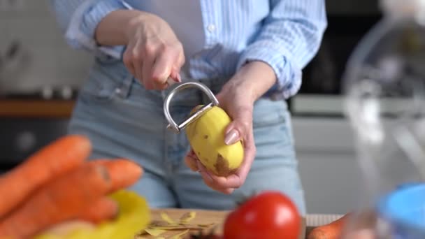 Hausfrau Kocht Gemüse Für Das Mittagessen Frau Schält Kartoffeln Mit — Stockvideo