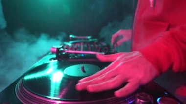 Hip hop DJ 'i, gece kulübünde pikapta plak plağı tırmalıyor. Disk jokeyinin bir partide müziği karıştırdığı 4K video klibini kapat