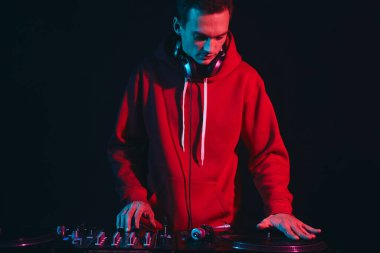 Kırmızı kapüşonlu Hip-Hop DJ 'i. Plak platformunda plak tırmalıyor. Havalı genç disk jokeyi bir partide plakları karıştırıyor. 