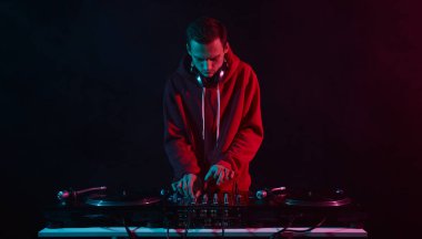 Bir partide plakları karıştıran havalı, genç bir disk jokeyi. Gece kulübünde DJ 'lik yapan beyaz erkek.