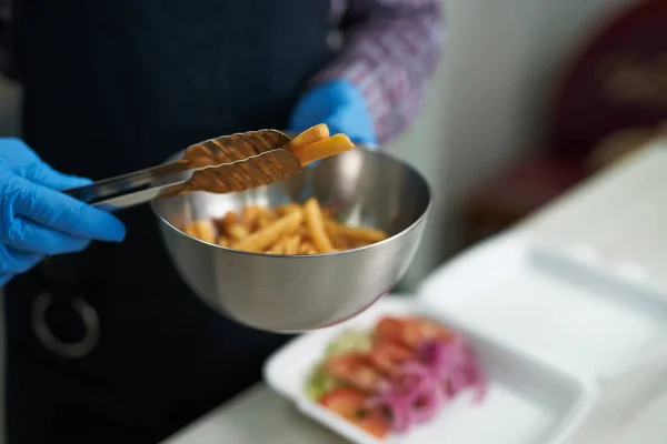 주방장 감자튀김을 통으로 카페에서 점심으로 패스트푸드를 준비하는 요리사 — 스톡 사진
