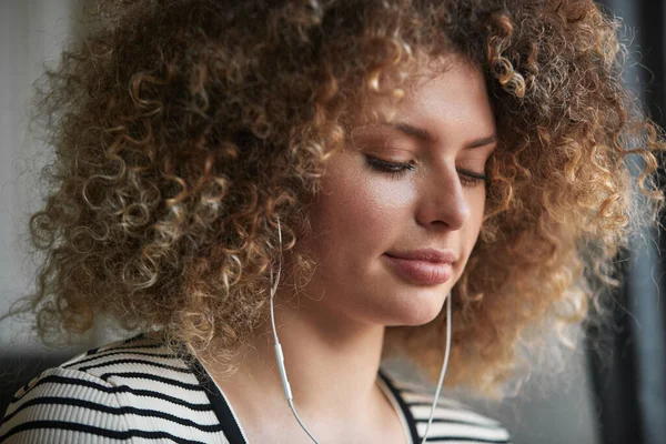 ヘッドフォンで美しい巻き女性の肖像 お気に入りの音楽をオンラインで聴く — ストック写真