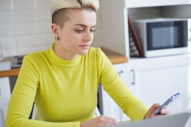Kısa saçlı, akıllı telefonunda mobil uygulama kullanan güzel bir beyaz kadın. Modern bir cep telefonu kullanan şık erkek çocuk portresi.