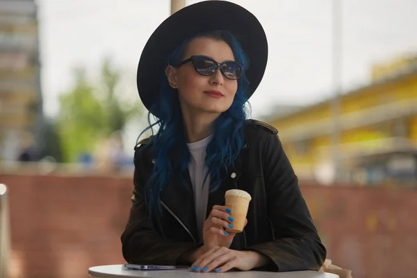 一个戴太阳镜 戴着嬉皮士帽 在街上咖啡店里吃冰淇淋的漂亮蓝头发女人的画像 多姿多彩的女性在阳光灿烂的天气里享受着户外甜点 — 图库照片