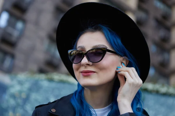 一个快乐多样的女人把无线耳机插入耳朵的肖像 美丽的女性 一头染成蓝色的头发 在户外欣赏音乐 — 图库照片