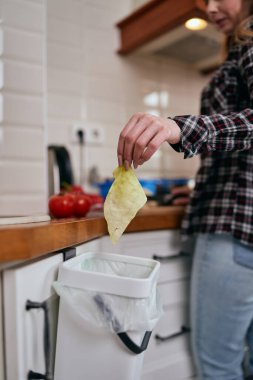 Aşçı fermantasyon için gübre kutusuna yiyecek kabukları atıyor. Sorumluluk sahibi bir kadın, organik artıkları evde bir Bokashi konteynerinde geri dönüştürüyor. Sürdürülebilir yaşam tarzı kavramı