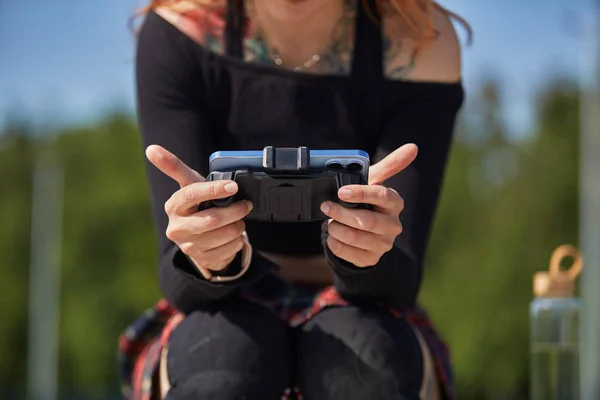 携帯電話でオンラインビデオゲームをプレイゲーマーの女の子 若い女性がスマートフォンの屋外でモバイルゲームをプレイ — ストック写真