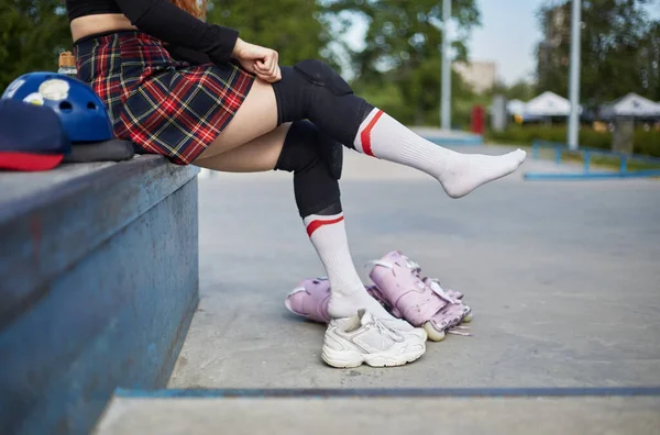 スケートの前に保護膝パッドを置くローラーブラダーの女の子 スケートパークでのライドの準備をする若いスケーターの女性 — ストック写真