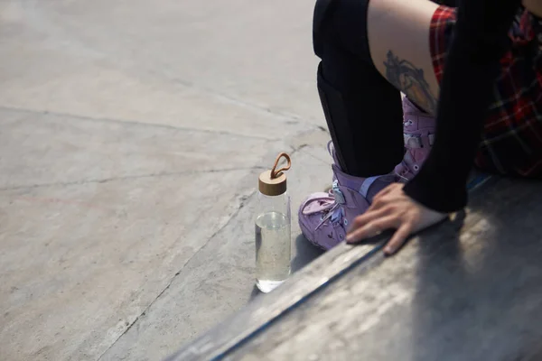 Κορίτσι Σκέιτερ Κάθεται Ένα Περβάζι Ένα Γυάλινο Μπουκάλι Φρέσκο Νερό — Φωτογραφία Αρχείου