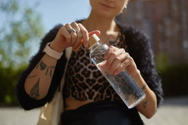 Μια Νεαρή Γυναίκα Τατουάζ Ανοίγει Ένα Γυάλινο Μπουκάλι Από Κοντά — Φωτογραφία Αρχείου