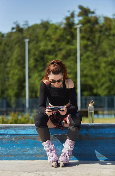 Paten Parkındaki Bir Çıkıntıda Oturan Akıllı Telefondan Oyun Sahası Eşliğinde — Stok fotoğraf