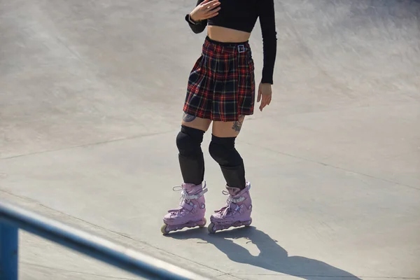 滑板女孩骑在一个混凝土滑板公园的激进在线滑板上 难以辨认的年轻女子在阳光灿烂的夏日室外滑冰 — 图库照片