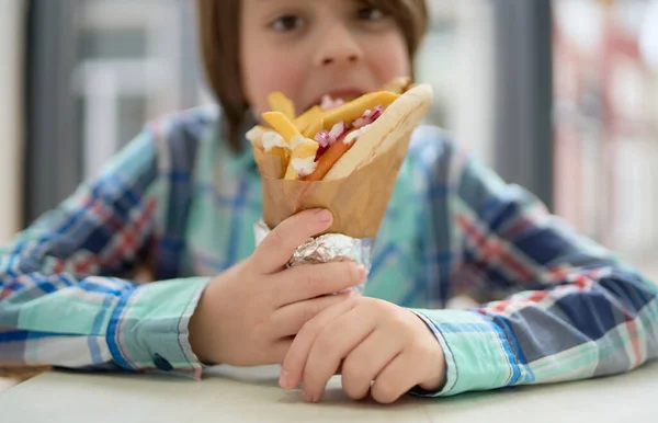ギリシャのファーストフードレストランでジャイロサンドイッチを噛んだかわいい男の子 カフェで軽食を楽しむ白い子供の写真を閉じます — ストック写真