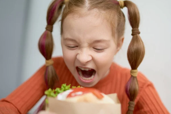 サンドイッチをかむ面白い女の子の肖像画 ギリシャのレストランでピタスブラキを一口飲んで空腹の子供 — ストック写真