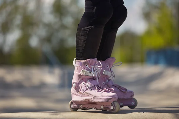 穿着紫色冰鞋的有侵略性的内联滑雪者女孩 夏季室外溜冰场中女性轮滑手的脚 — 图库照片