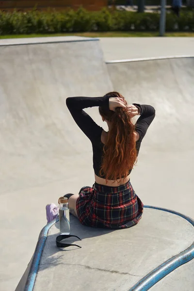 Vrouwelijke Schaatser Zittend Een Hellingbaan Met Een Glazen Fles Water — Stockfoto