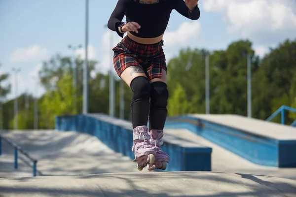 スケートパークに乗っている若いスケーターの女の子 屋外コンクリート公園で積極的なインラインローラーブラダー女性スケート — ストック写真