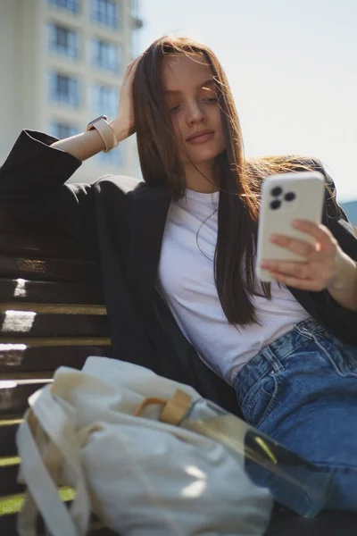 Güzel Genç Bir Kadın Bir Bankta Akıllı Bir Telefonla Mobil — Stok fotoğraf