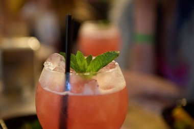 Bardaki bir partide servis edilen nane yaprağı ve romlu pembe yaz kokteyli. Cin ve meyve suyuyla uzun içkinin tadını çıkar.