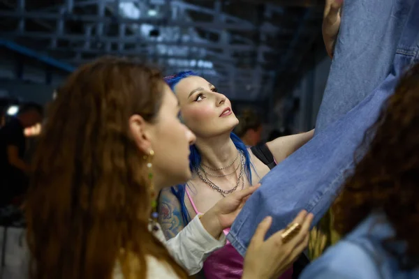 自由市場でジーンズの服のためのレズビアンカップルのショッピング 二人の若い多様な女性を選ぶヴィンテージデニム服でAスリフトショップ — ストック写真