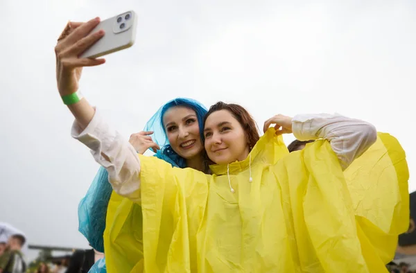 快乐的女同性恋夫妇穿着雨衣自拍 两名不同的年轻女子在雨天在户外摆出一张自拍照片 — 图库照片