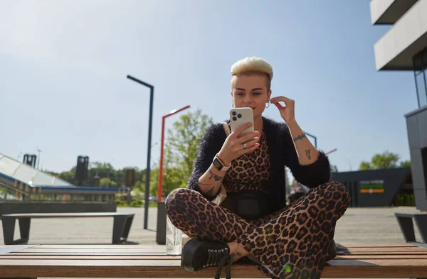 时尚多样的女人在网上听音乐 一个穿着豹纹衣服 短发的时髦女性的画像 — 图库照片