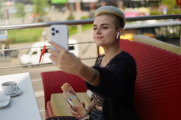 Šťastný Rozmanitý Ženský Model Krátkými Vlasy Pózující Pro Selfie Lahví — Stock fotografie