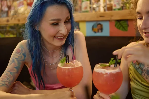 快乐的蓝头发女性和她的女朋友在酒吧里喝鸡尾酒 一对快乐的女同性恋 男同性恋 双性恋和变性者夫妇的画像 — 图库照片