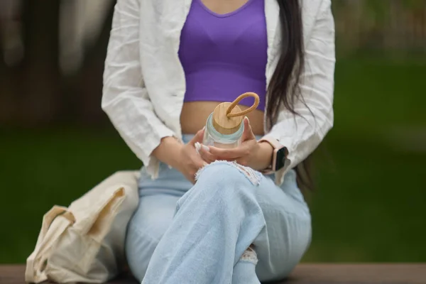 Jonge Vrouw Zittend Een Bank Met Een Glazen Waterfles Handen — Stockfoto